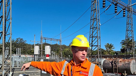 man in high viz safety clothing at high voltage power station